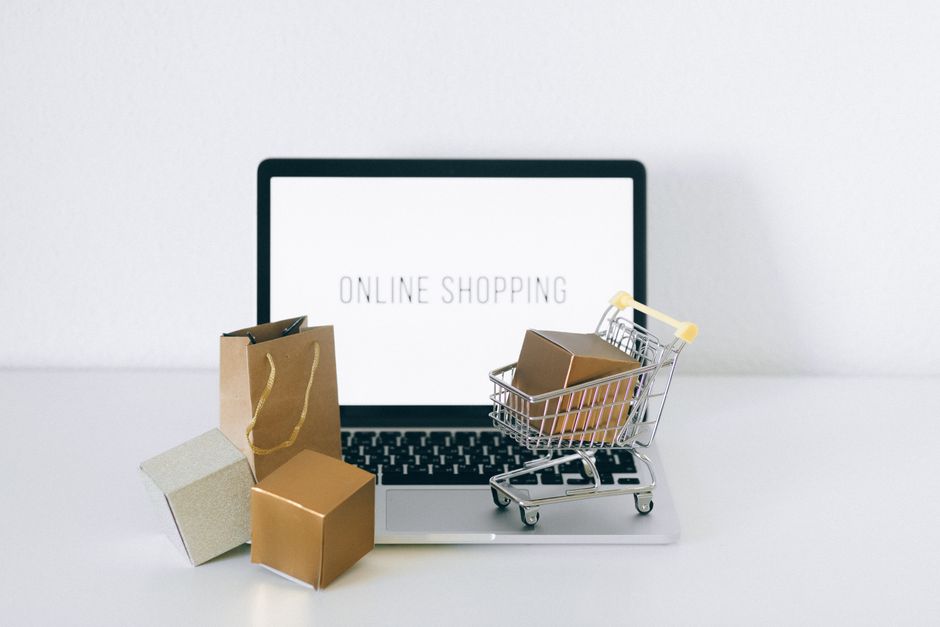 Computadora con tienda en línea abierta y paquetes de un pedido de dropshipping