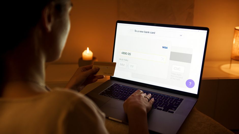 Persona realizando una compra online con tarjeta desde su computadora