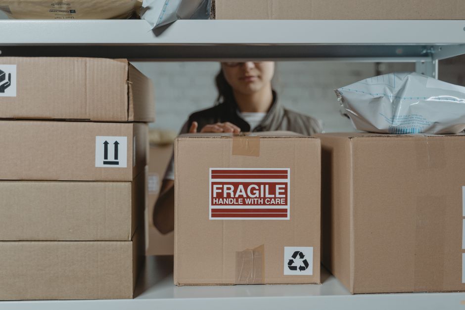 Emprendedora costarricense empacando un pedido en caja de cartón para enviarlo por Correos de Costa Rica