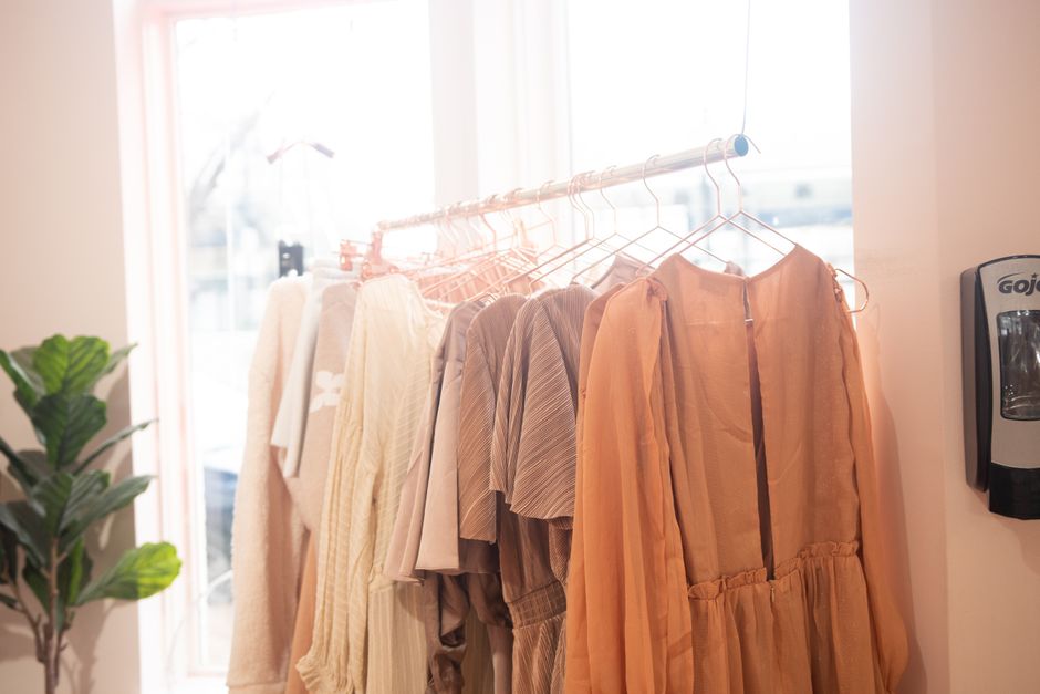 Prendas de ropa organizadas en percheros para una boutique en línea en Costa Rica